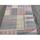 A modern Gustavo rug woven with grey, mauve and cream patchwork panels with geometric designs. (