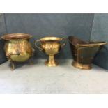 A helmet shaped brass coal scuttle with swing handle; a brass log bin with embossed ribbon swagged