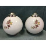 A pair of milk glass globe lights with floral rose decoration, having chromed mounts/fittings. (
