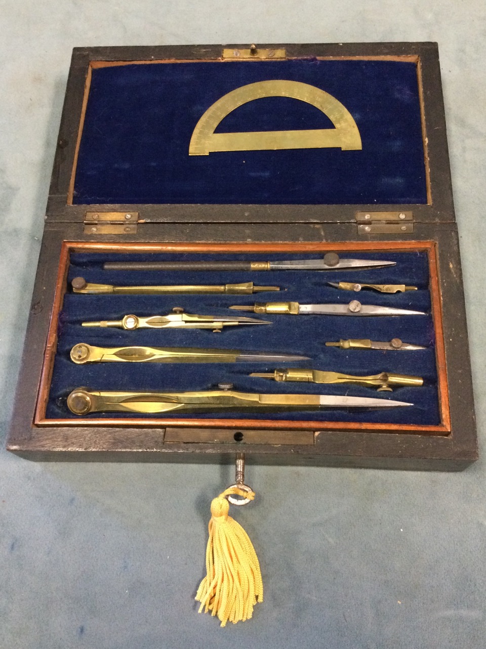 A rosewood cased set of brass drawing instrument, the lined box with fitted internal tray. (8.25in)