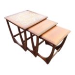 A nest of teak G-plan tables, the largest with tile top, the three graduated tables on rounded