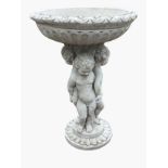 A composition stone garden birdbath, the circular fluted bowl with floral rim supported by three