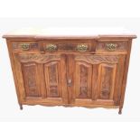 A late Victorian carved mahogany sideboard with breakfront moulded top above three frieze drawers