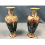 A pair of Royal Doulton tapering stoneware vases with waisted necks, having applied swagged