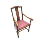 An oak armchair with rectangular plain shaped splat to back and scrolled moulded arms on turned