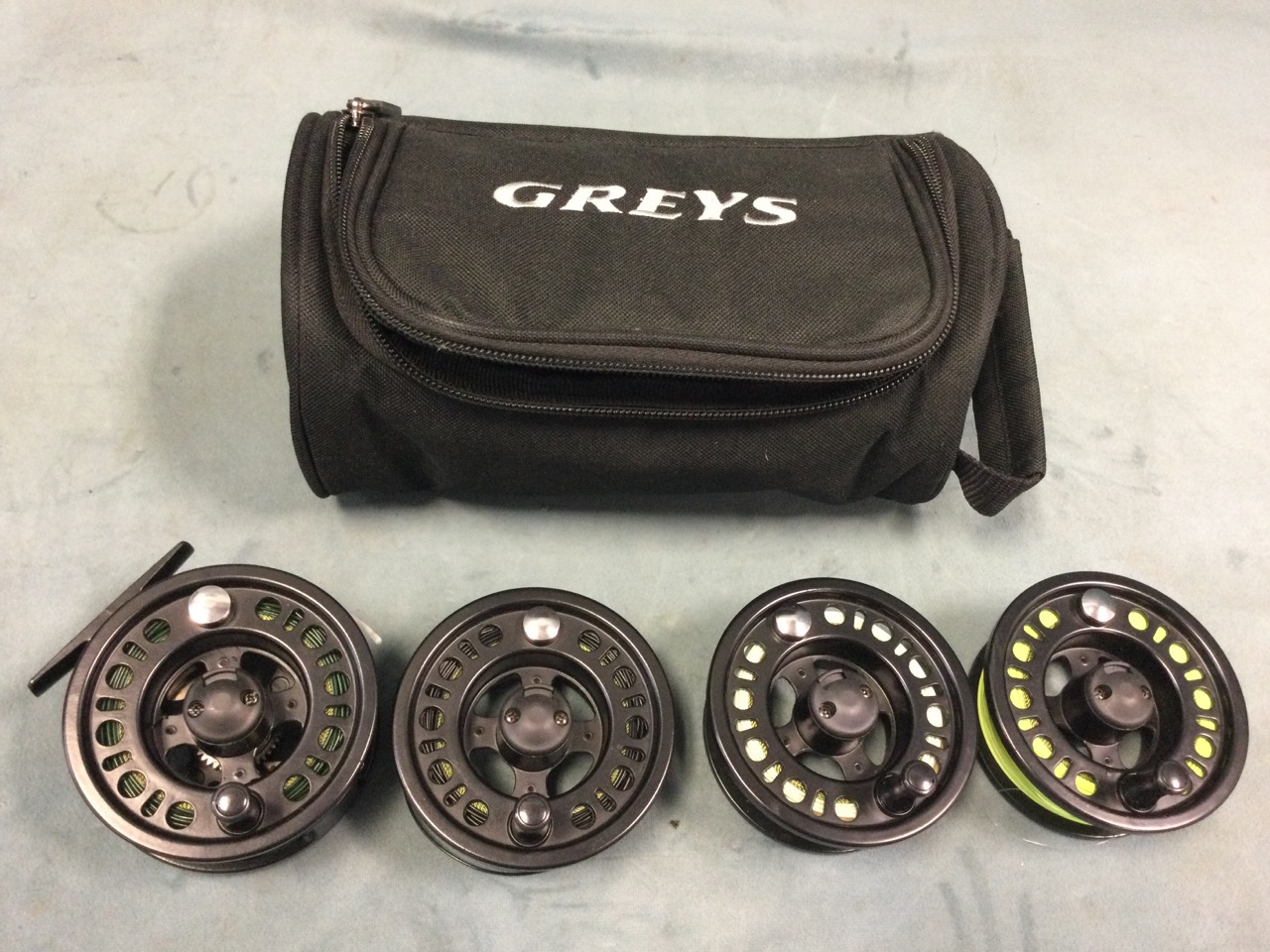 A 3.5in trout fly reel, and three interchangeable spools, in a Greys reel bag - four different