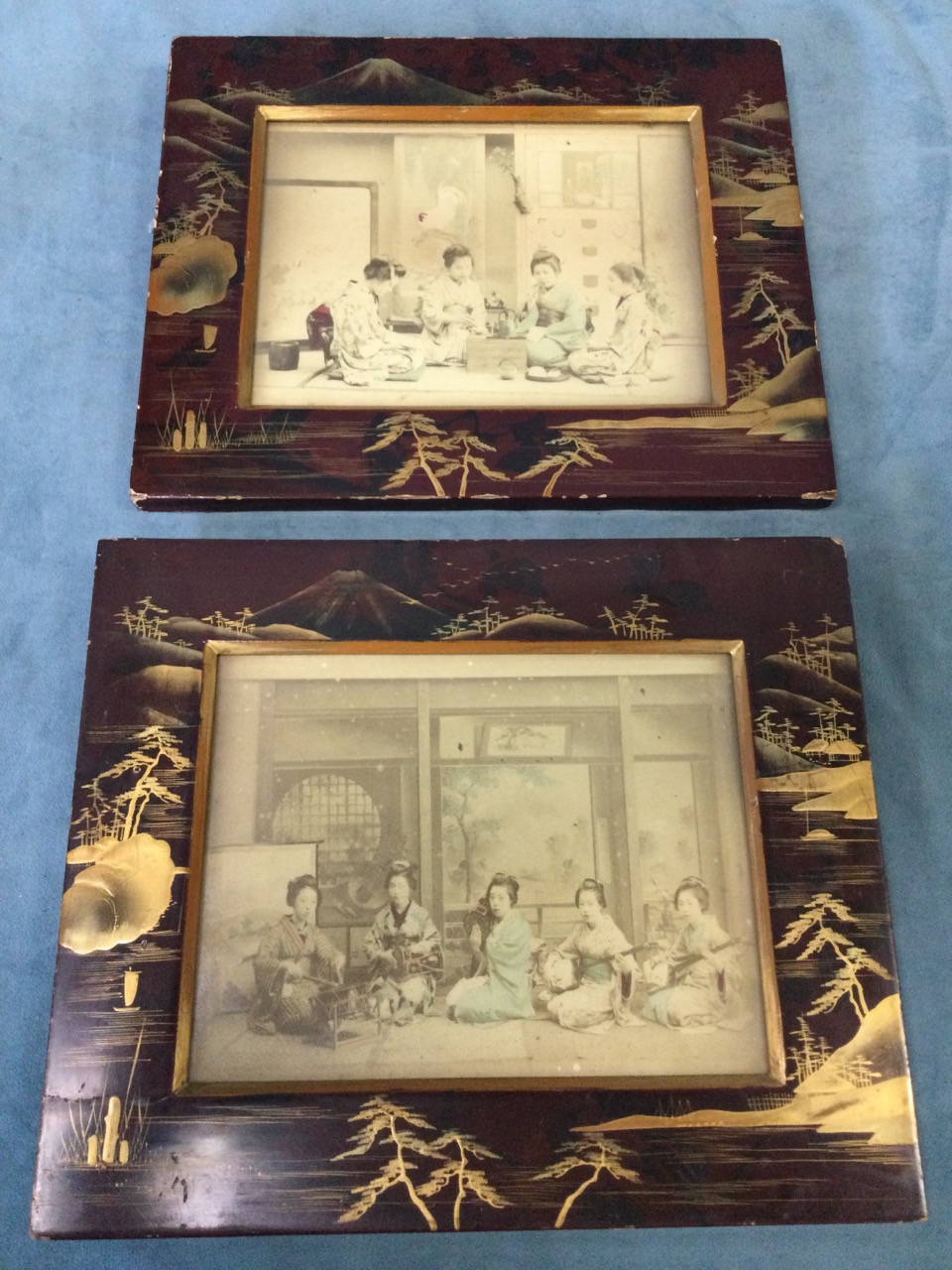 A pair of late nineteenth century Japanese lacquered frames gilded with landscapes and trees on