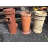 A plain tubular terracotta chimney pot with moulded foot; another terracotta pot with three side