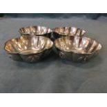 A set of four hexagonal eastern silver bowls of lobbed form, each panel with applied circular buddha