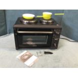 An unused Silver Crest tabletop mini cooker with two circular hotplates above a drop-down oven