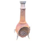 A cast iron chimaera patio stove with tapering chimney above ovoid burning chamber having grill