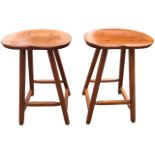 A pair of American hardwood kitchen stools with wide kidney shaped saddle seats on square