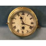 An Edwardian brass cased marine bulkhead clock complete with key, the dial with roman chapters and