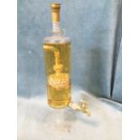 A novelty bottle of Highland Malt Scotch Whisky in the shape of a tall carafe with a small tap,