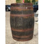 An old oak whiskey barrel, the staves bound by six metal strap bands. (35in)