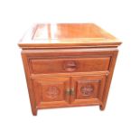 A square Chinese hardwood cabinet with panelled top above a drawer and cupboard carved with tsuba