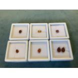 A boxed Hessonite oval garnet of approx 1.5 carats; a pair of red pear-cut quartz stones weighing.