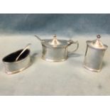 A three-piece hallmarked silver cruet set of oval form with ribbed moulded borders, the mustard &