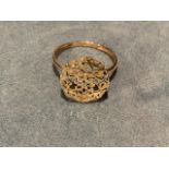 A 9ct yellow gold ring, the pierced octagonal panel on flowerhead type cage, mounted on a slim