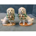 A pair of nineteenth century German porcelain dogs seated on their haunches holding baskets of