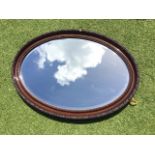 An oval Edwardian mirror with bevelled plate in moulded frame. (28in x 18.5in)