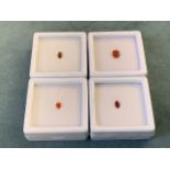 Four boxed/cased loose opals - an oval fire opal - 0.4 carats, a pear-cut fire opal - 0.1 carats,