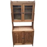 A glazed pine dresser with shaped sides, the cupboard to top above an open compartment, the base