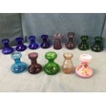 A collection of coloured bulb vases - blue, green, purple, pink, one decorated with leaves &