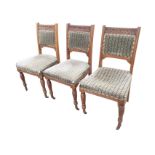 A set of three late Victorian carved oak dining chairs with floral roundels to back rails above