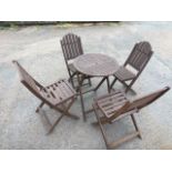 A folding garden table and chair set with two pairs of chairs having slatted backs & seats, and a