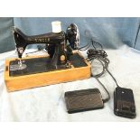 A singer electric sewing machine with foot pedals.