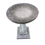 A composition stone birdbath with circular bowl on baluster column above a square plinth base. (17.