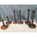 Three pairs of twisted oak candlesticks, two pairs with circular turned saucer bases, and one pair