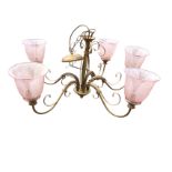 A copper painted hanging wrought iron light fitting suspended by chain from bun shaped ceiling rose,