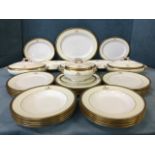 A Staffordshire Cauldon dinner service decorated with greek key gilt borders to pale yellow bands,