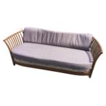 A modern 6ft Ercol ash sofa with tubular curved rails on slats having loose cushion back and seat,