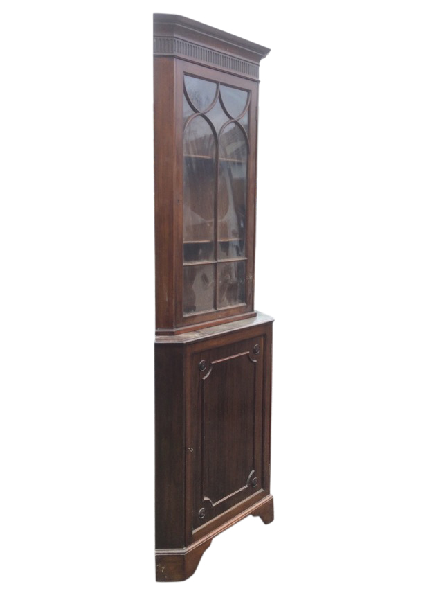 A Georgian style mahogany corner cabinet with moulded cornice above a fluted frieze having arched
