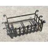 A wrought iron fire basket framed by scrolled vertical slats to rectangular cage. (27in x 15in x