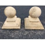 A pair of square composition stone painted pillar capitals, with ball finials on waisted and moulded