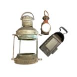 A large galvanised ships lamp with brass Anchor label; a red painted signalling oil lamp; and a