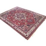 An Axminster carpet woven in the oriental taste with central star lozenge on red field with