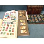 A schoolboy stamp collection contained in two albums; two albums of cigarette cards - Ogdens,