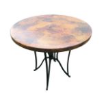 A contemporary circular garden table with hammered copper finish to top, supported on a waisted