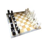 A North American marble chess set, the pieces of carved totem pole style design on fawn and ivory