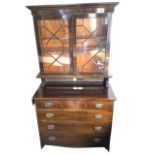 A stained late Victorian bookcase cabinet with moulded cornice above astragal glazed doors enclosing