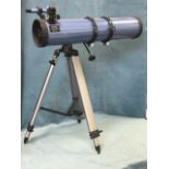 A contemporary Sky-watcher telescope on adjustable telescopic tripod stand with weighted balance.