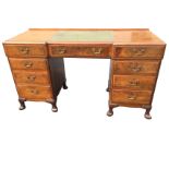 A mahogany kneehole desk by Whytock & Reid, the moulded caddy top of breakfront outline set with