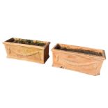 A pair of rectangular terracotta garden troughs with moulded rims, cast with swags to side panels,