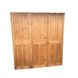 A set of three pine fielded panel doors, each with four panels, mounted with knobs, two with rebates