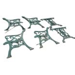 A cast iron garden table & chair set with scrolled decoration to frames raised on channelled sabre